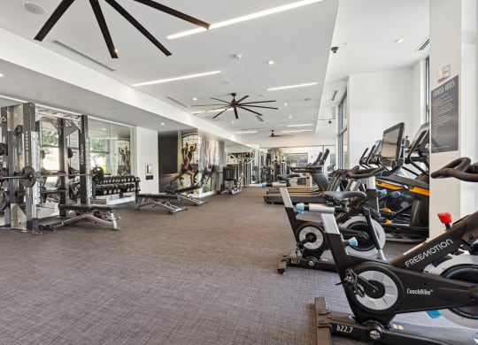 a spacious fitness center with cardio machines and other exercise equipment