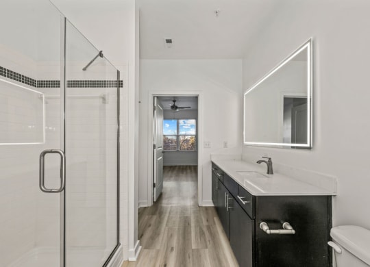 a white bathroom with a sink and a shower