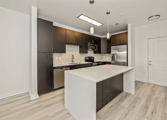 a kitchen with a large island and stainless steel appliances