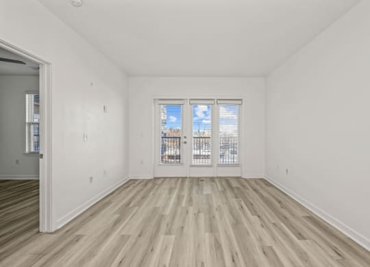 A room with a window and wooden flooring.
