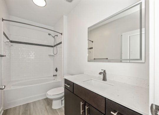 A white bathroom with a toilet, sink, and shower.