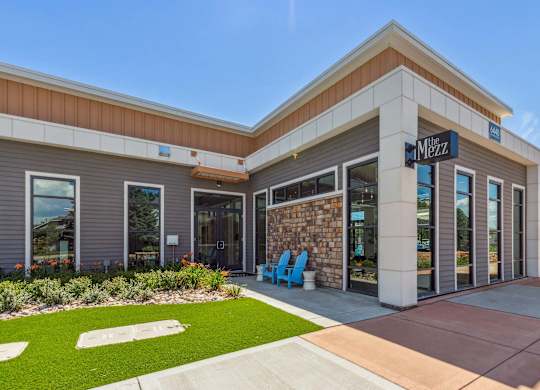 The Menza storefront with a blue chair in front.