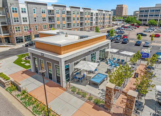 A parking lot with cars and a building with a brown roof.