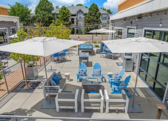 A patio with blue and white chairs and umbrellas.
