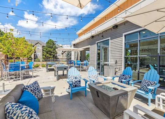 A patio with blue chairs and a white table.