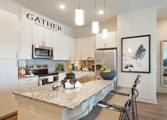 A kitchen with a granite countertop and a sign that says