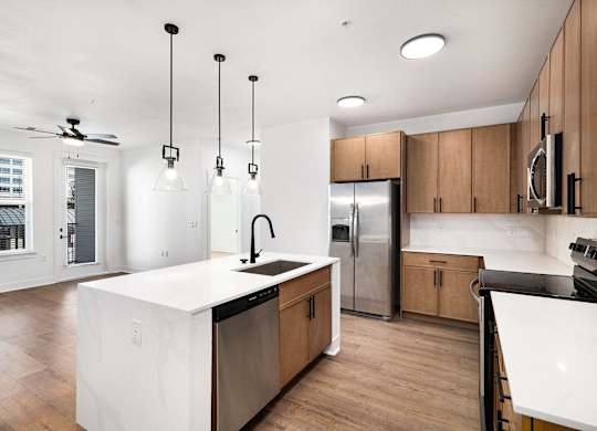 A modern kitchen with wooden cabinets and a white island.