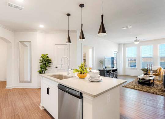 A modern kitchen with a large island and pendant lights.