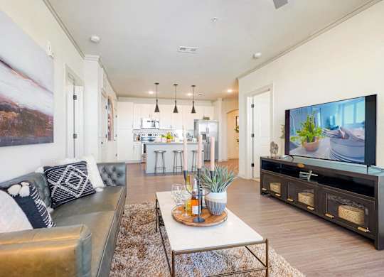A modern living room with a large couch and a television.