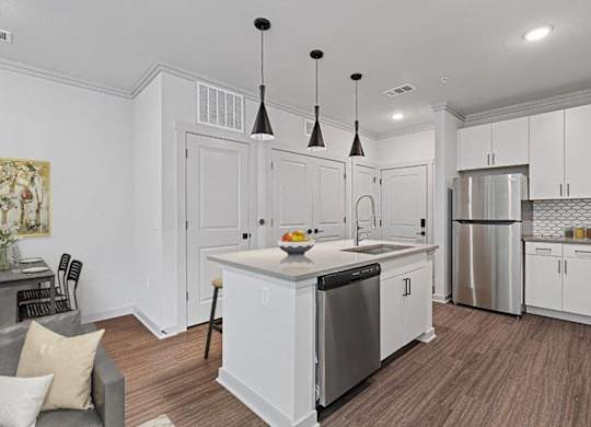 A kitchen with white cabinets and a wooden floor.