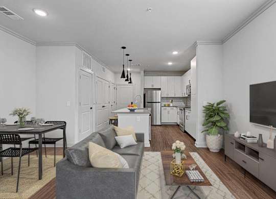 A modern living room with a grey couch and a dining table.