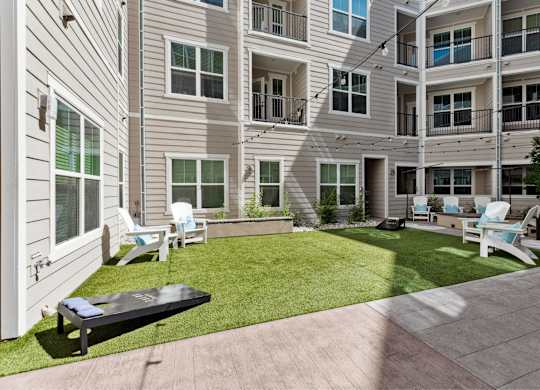 A sunny day at a residential complex with a green lawn and a black table.