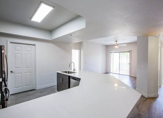 A white kitchen with a sink and a window.
