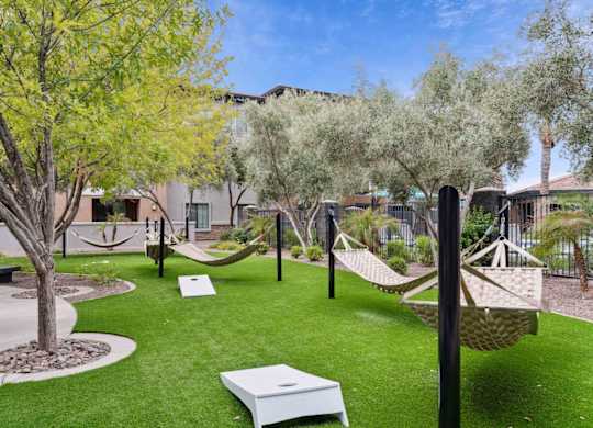 A backyard with a white hammock and a white table.