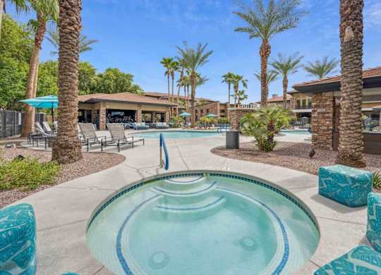 A pool surrounded by palm trees and lounge chairs.