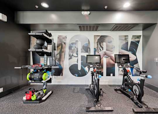 A room with exercise bikes and a wall with a large letter "A" on it.