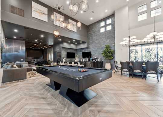 A pool table is in the middle of a room with a stone wall and a bar area.