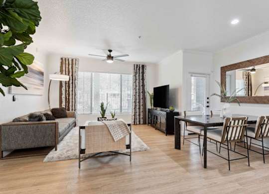 A living room with a brown couch, a coffee table, and a television.