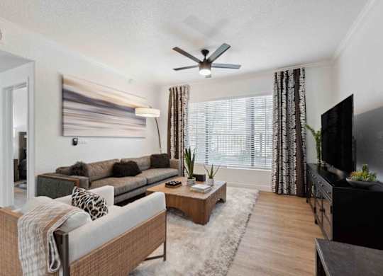 A living room with a grey couch and a wooden coffee table.