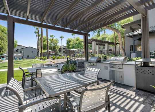 A patio with a table and chairs under a roof.