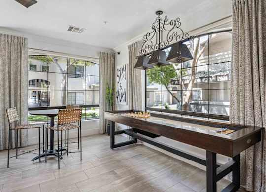 A dining room with a wooden table and chairs.