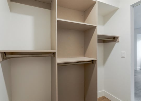 A white wall with a shelf and a doorway.