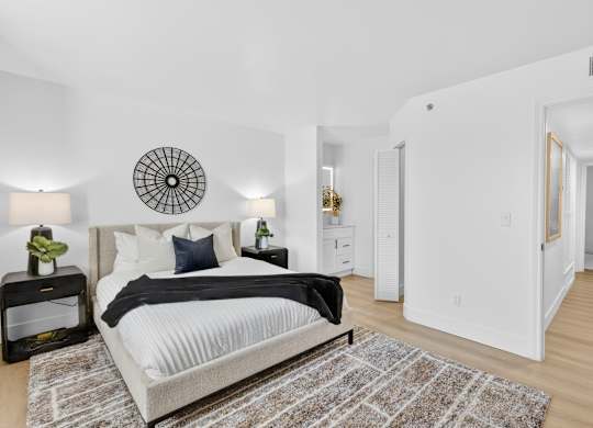 A bedroom with a large bed and a round decorative item on the wall.