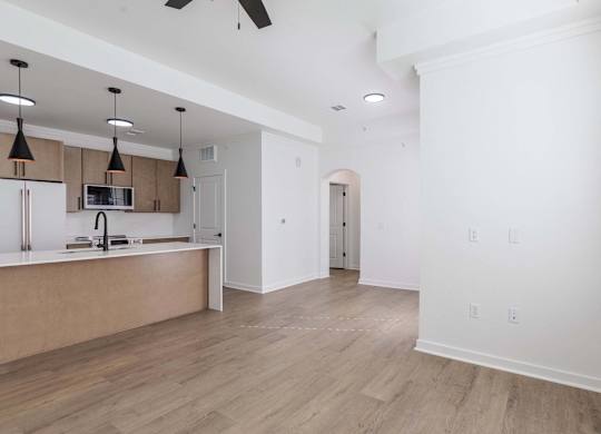A kitchen with a refrigerator, microwave, and oven.