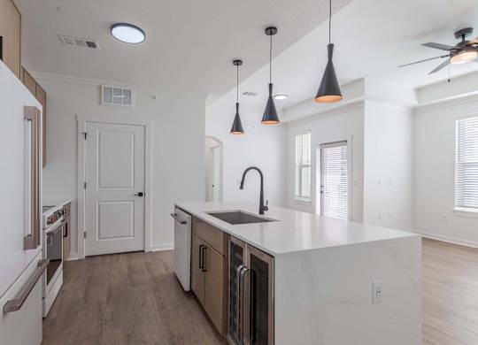 A kitchen with a white counter top and a ceiling fan.