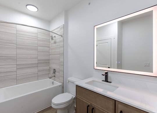 A white bathroom with a toilet, sink, and bathtub.