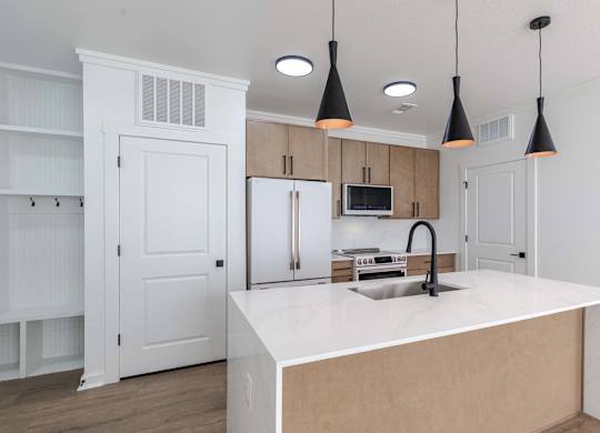 A kitchen with a white countertop and a sink.