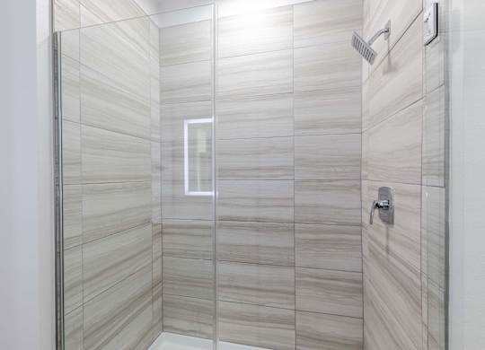 A modern bathroom with a glass shower stall.