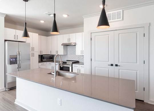 A kitchen with a white counter and cabinets.
