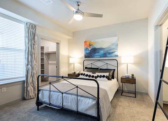 A bedroom with a large bed and a ceiling fan.