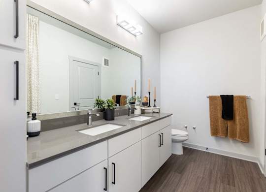 A bathroom with a white sink and a brown towel hanging on the wall.