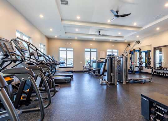 A spacious gym with treadmills, elliptical machines, and other exercise equipment.