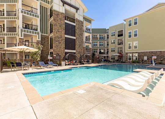 A large swimming pool surrounded by apartment buildings.