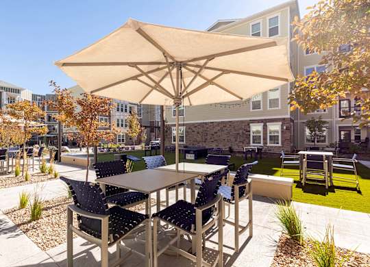 A patio with a table and chairs under an umbrella.