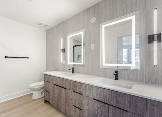 A bathroom with a toilet, sink, and mirror.