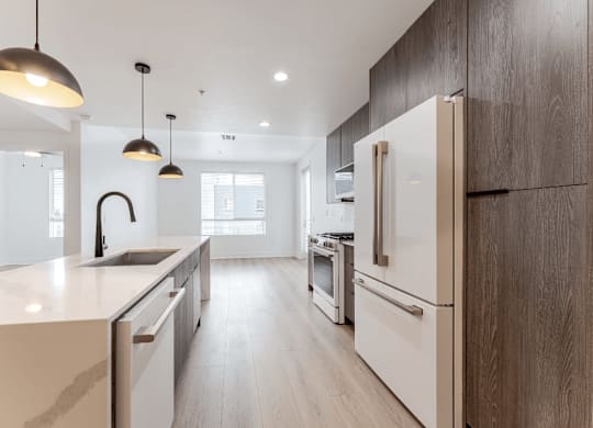 A modern kitchen with a white countertop and wooden cabinets.