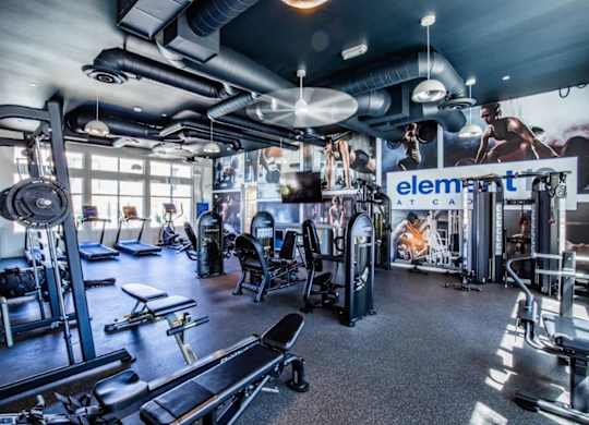 A gym with a variety of equipment including treadmills, weights, and exercise machines.
