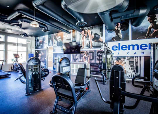 A gym with a variety of equipment including treadmills, stationary bikes, and weight machines.
