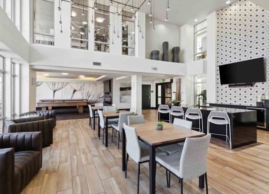 a common room with tables and chairs and a foosball table
