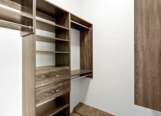 A brown wooden shelf with glass panes is mounted on a white wall.