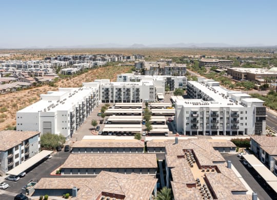 a cityscape of white buildings with a desert in the background