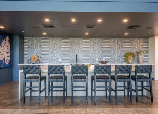 a large table with chairs in front of a wall with a geometric pattern