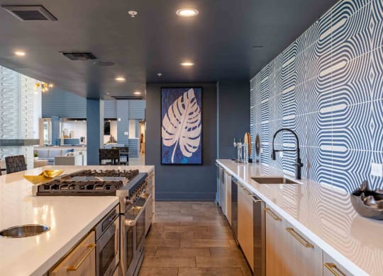 a large kitchen with white countertops and a large painting on the wall