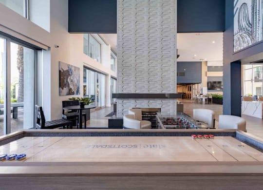 a shuffleboard table in a clubhouse with a fireplace