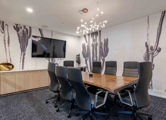 a conference room with a table and chairs and a tv on the wall