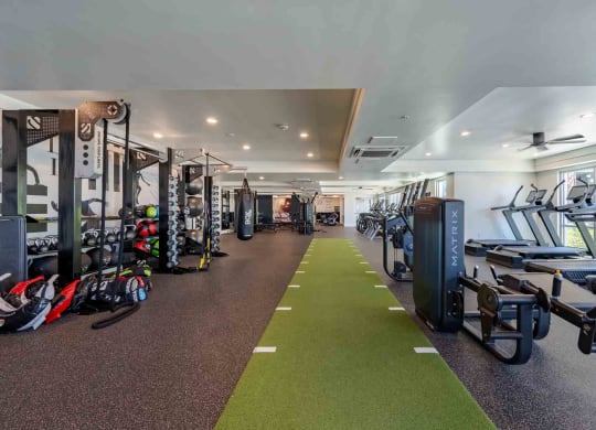 a spacious fitness center with cardio machines and weights